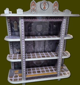 A multi-tiered shelf with a decorative design, featuring three open shelves and a detailed back panel, designed for displaying items.